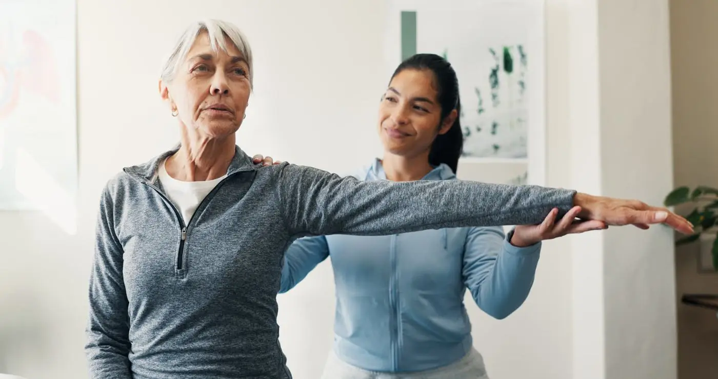 Physiotherapist guiding an older patient through a shoulder stretch at Gogodoc Physio